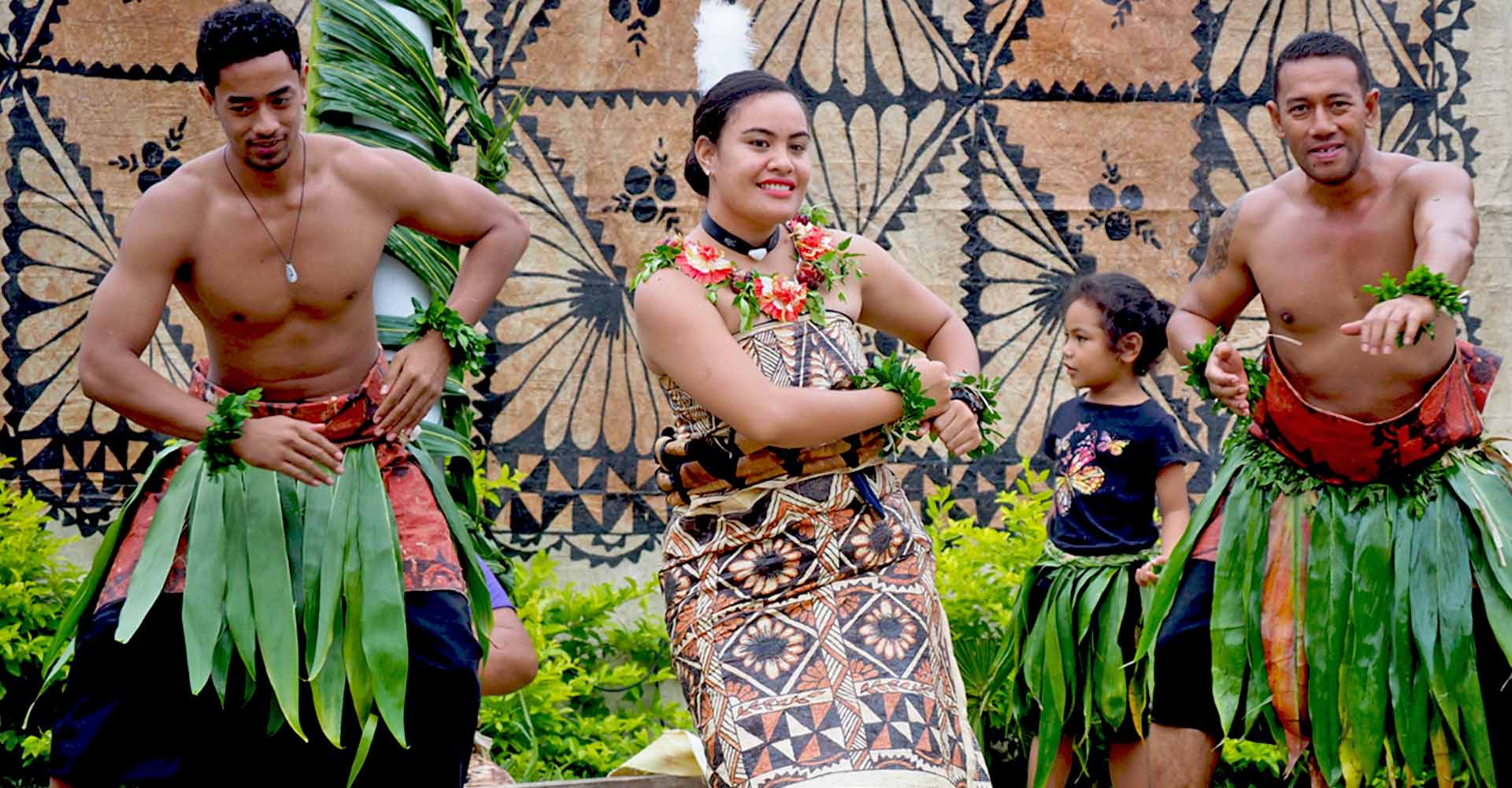 Tongan men and women performing a traditional dance in cultural attire, showcasing the rich heritage of Tonga.
